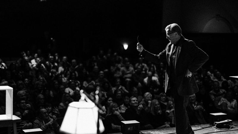 Rich Crawford performing a mentalism show on stage for a large corporate audience