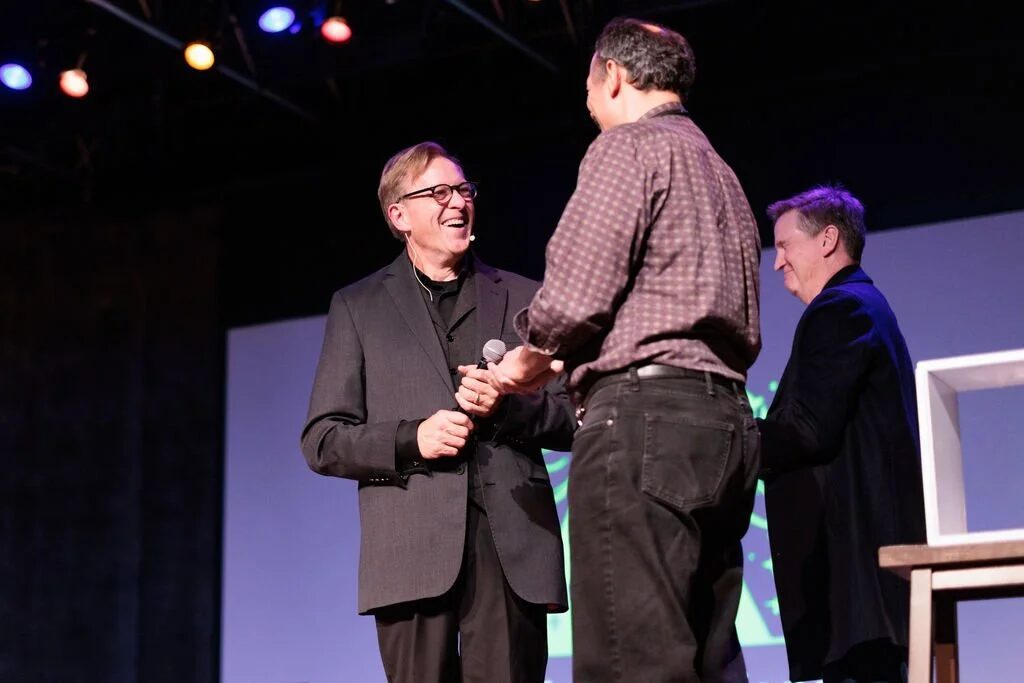 Rich Crawford on stage with an audience volunteer during a corporate magic show