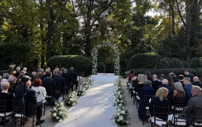 Outdoor garden wedding ceremony with a white aisle and flowers